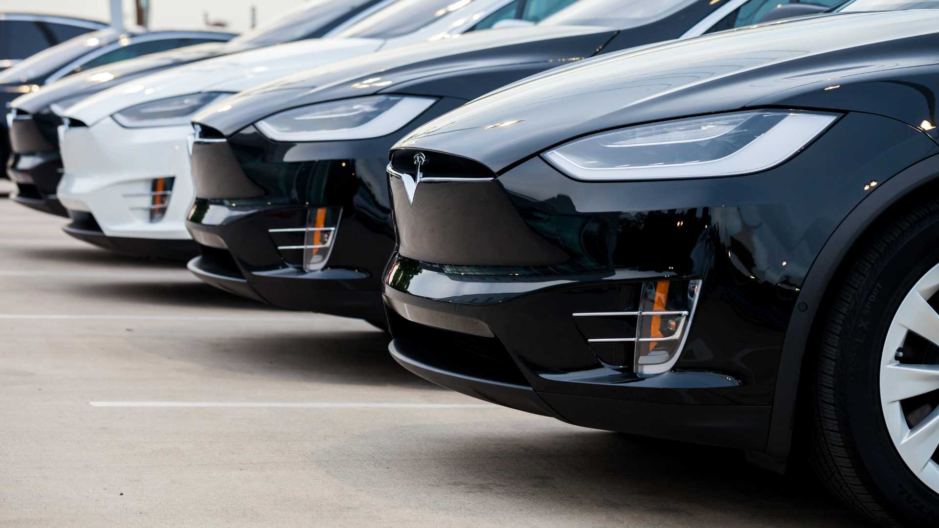 Row of new Tesla Model X electric cars in front of dealership